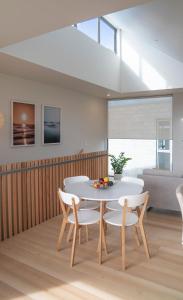 拉格伦Coastal Living in Comfort的一间配备有白色桌椅的用餐室