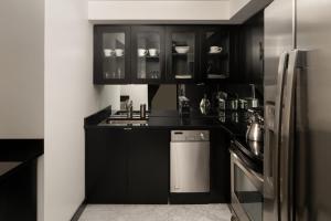 纽约曼哈顿俱乐部酒店的厨房配有黑色橱柜和不锈钢冰箱