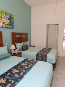 巴亚尔塔港Casa las Flores的酒店客房设有两张床和一张桌子。