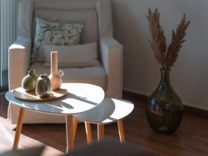 雅典Marousi Cozy Apartment的客厅配有椅子和带花瓶的桌子