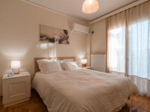 雅典Marousi Cozy Apartment的卧室配有白色的床和窗户。