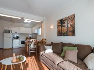 雅典Marousi Cozy Apartment的客厅以及带沙发和桌子的厨房。