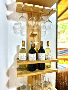 奥隆La Cabaña de Victor的装有酒瓶和玻璃杯的架子