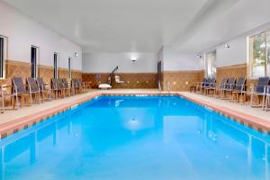 盖恩斯维尔盖恩斯维尔乡村套房酒店的大楼内带椅子的游泳池