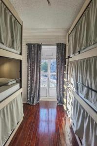 里斯本Samps Hostel的客厅设有窗户,铺有木地板