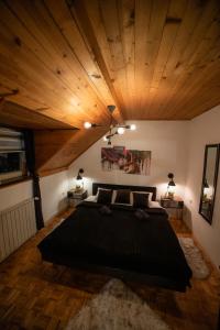 博尔Vila Jezerski raj的一间卧室设有一张大床和木制天花板。