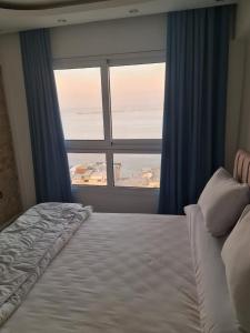 亚历山大شقة فاخرة مكيفة تري البحر مباشرة的一间卧室设有一张床和一个大窗户