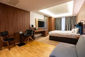 蒂米什瓦拉ATLAS Hotel的配有一张床和一张书桌的酒店客房