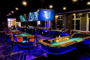 戴德伍德天丽兹博彩度假村汉普顿酒店的赌场配有桌椅和视频游戏