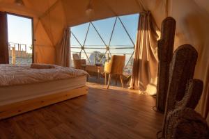 TamriTimlalin Dome的一间卧室配有一张床、一张桌子和一个大窗户