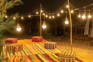 TamriTimlalin Dome的桌子上配有毯子和灯,椅子上