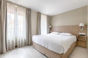 巴黎马莫泰星晨酒店的一间卧室设有一张大床和一个大窗户