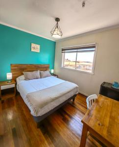 维纳德马Hostal Terraza Recreo的一间卧室配有一张蓝色墙壁的床和一扇窗户