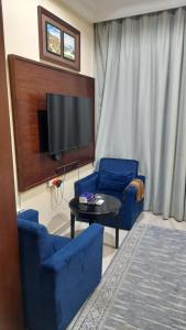 达瓦迪米شقق مساكن السمو المخدومة的客厅配有2把蓝色椅子和电视