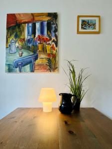 巴特赫尔斯费尔德Gästehaus Keins wie meins的一张桌子,上面有台灯和墙上的绘画