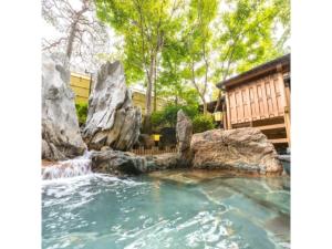 气仙沼市Sun Marine Kesennuma Hotel Kanyo - Vacation STAY 21044v的后院带岩石的瀑布池