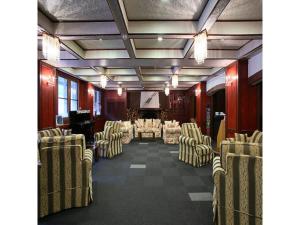 志贺高原Shiga Palace Hotel - Vacation STAY 22531v的配有椅子和桌子的房间和舞台