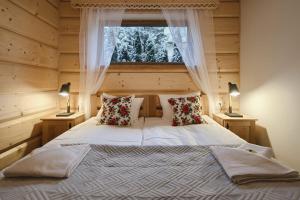 穆扎希赫尔Galicowa Chata的一间卧室配有一张带窗户和两盏灯的床。