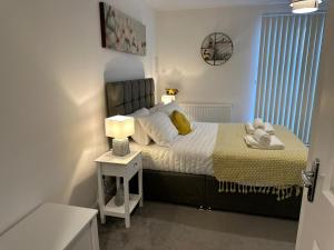 伯明翰Munalux 2 bed的一间卧室配有一张床和一张带台灯的桌子