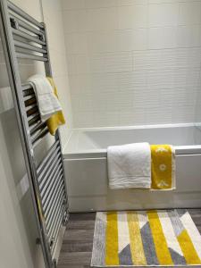 伯明翰Munalux 2 bed的浴室配有带黄白色毛巾的浴缸。