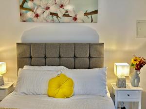 伯明翰Munalux 2 bed的床上的黄色枕头