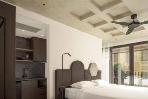 海若克利欧Pleiades Urban Stay by Semavi的一间卧室配有一张床和吊扇