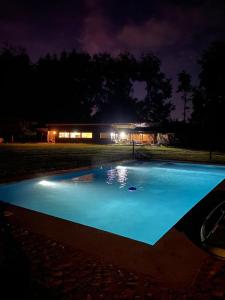 瓦尔迪维亚Valdivia Tralcao Lodge的一座大型蓝色游泳池,在晚上在大楼前
