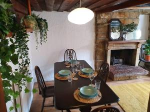 罗宾胡兹贝Bramblewick Cottage的一间带桌子和壁炉的用餐室