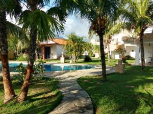 El CardónVilla Cocuyo - Studios & Apartments的一个带游泳池和棕榈树的度假村