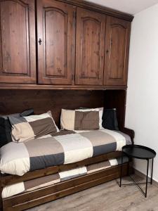 博格塔塞斯特雷da Robi appartamento fronte piste的一张带木柜的床和一张桌子
