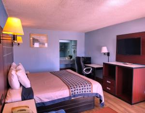 里奇兰Rodeway Inn的配有一张床和一张书桌的酒店客房