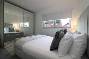 格拉斯哥Glas-Go 2 bedroom Apartment 3 min walk to SECC Hydro FREE PARKING ONSITE的卧室配有带枕头的大型白色床