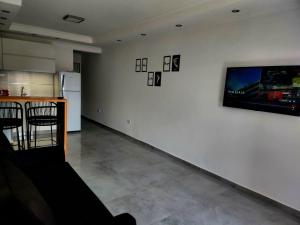 内科切阿F&E Apartment的一间设有白色墙壁和平面电视的客房