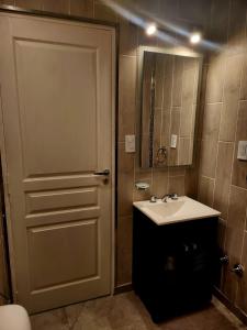 内科切阿F&E Apartment的浴室设有门、水槽和镜子
