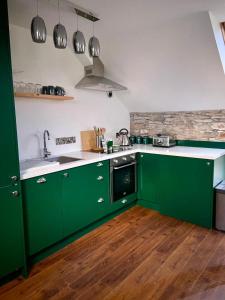 肯梅尔Bill's Barns Apartment 2的绿色厨房配有水槽和炉灶