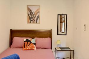 阿布拉奥Casa Matatiso - quartos privados em casa compartilhada的一间卧室配有一张带粉色床单和一张桌子的床。
