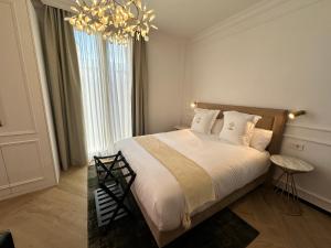 格拉纳达Bubaqia House - Suites Boutique的一间卧室配有一张大床和一个吊灯。