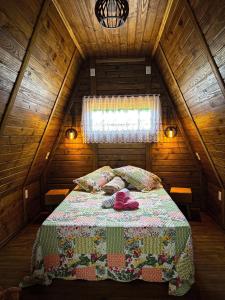 上大瓦尔任Chalé de Madeira em Vargem Alta的木制阁楼卧室配有一张床