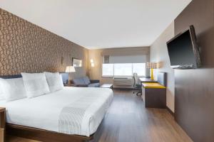 米西索加GLō Best Western Mississauga Corporate Centre的酒店客房设有一张大床和一台电视。
