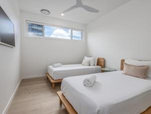 黄金海岸Palm Paradise: Luxury Villa Escape by the Beach的白色的客房设有两张床和窗户。