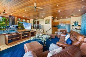凯恩斯Barong Luxury Home overlooking Cairns Unrivalled privacy and location的客厅配有皮革家具和吊扇