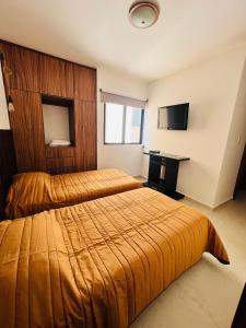 GuadalupeTorre Riviera veracruzana的酒店客房设有两张床和电视。
