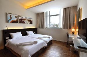 马六甲MIO BOUTIQUE Hotel的酒店客房设有两张床和一台平面电视。