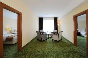 乌兰巴托蒙古阿尔法酒店的酒店客房配有桌椅和一张床