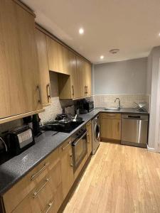 WorleNewly Refurbished 2 Bedroom Apartment Weston Super Mare的厨房配有木制橱柜和不锈钢用具