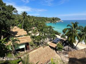 班泰Apsara & Dragon’s Supra Wellness Resort的享有海滩美景,设有房屋和大海