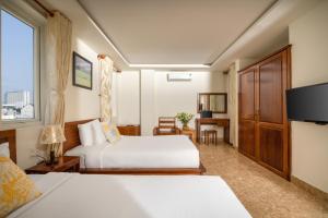 岘港岘港泰坦酒店的酒店客房设有两张床和电视。