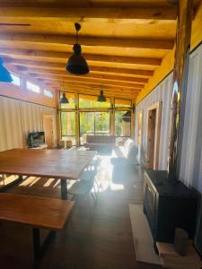 里坎雷Pucura Eco Lodge的客厅设有木制天花板和桌子