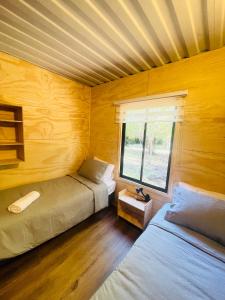 里坎雷Pucura Eco Lodge的一间卧室设有两张床,其中设有窗户。