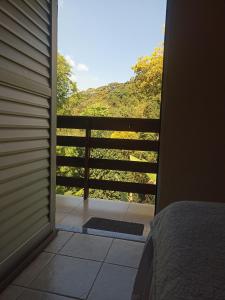 帕科蒂Pousada Rota Do Beija Flor PACOTI-CE的卧室门享有阳台的景致